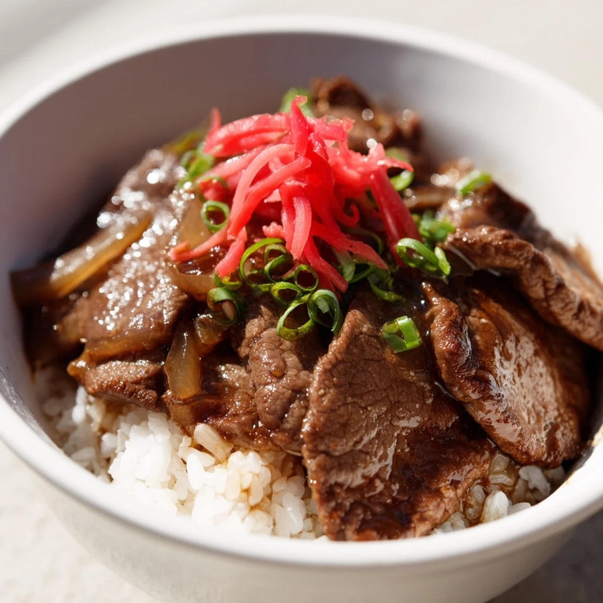 Tender beef and onions simmered in savory sauce over fluffy rice in a Beef Bowl with Rice.