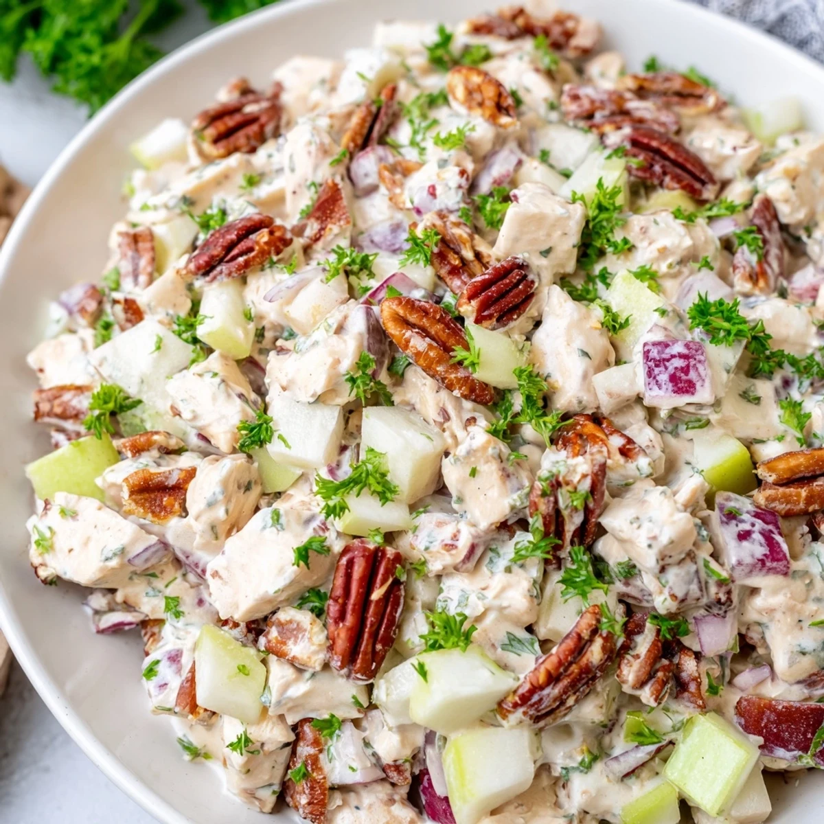 Creamy Chicken Pecan Salad tossed with crunchy pecans and crisp apples in a wooden bowl, perfect for a light lunch.
