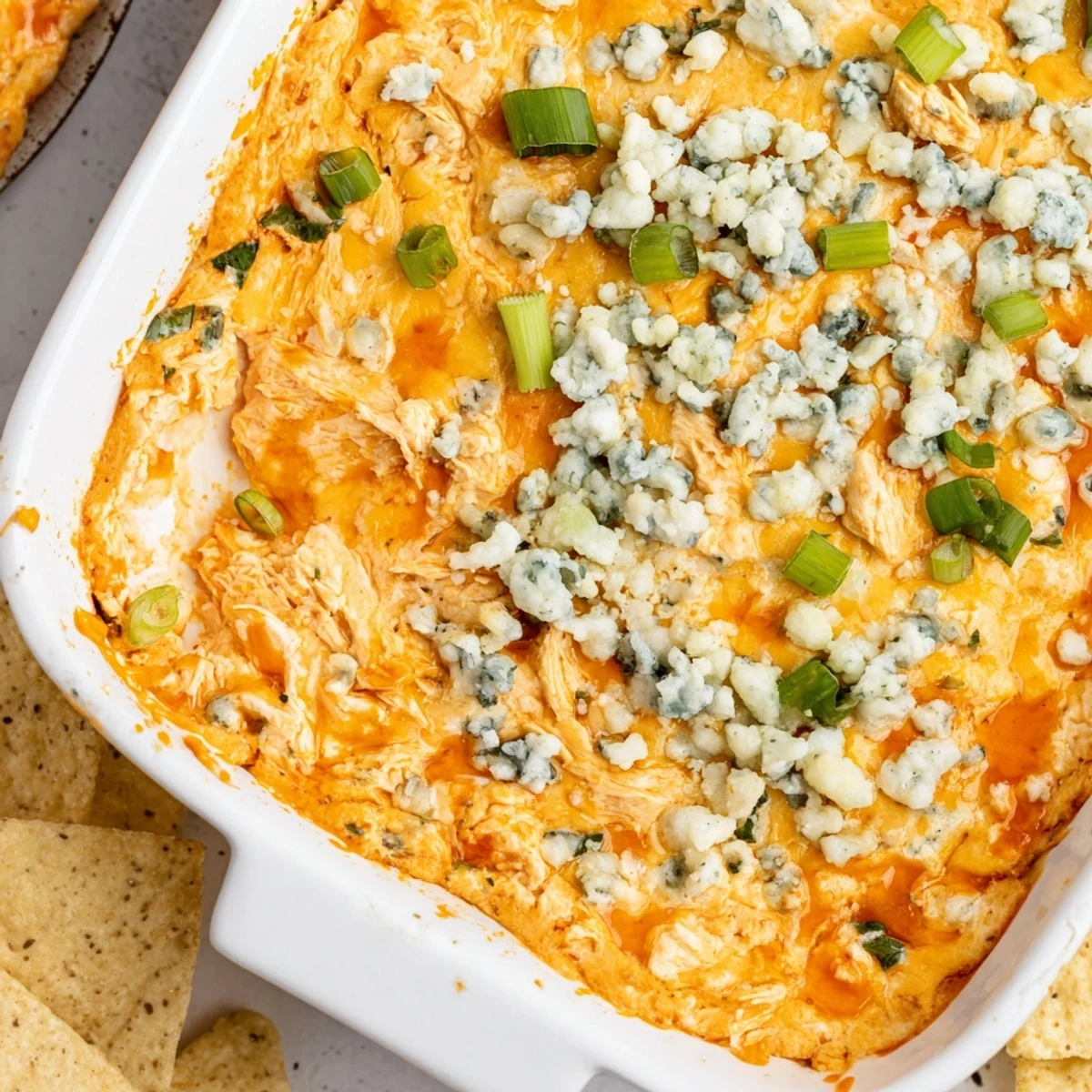 Savory Spicy Buffalo Chicken Dip with shredded chicken, cheese, and buffalo sauce, paired with crispy tortilla chips.