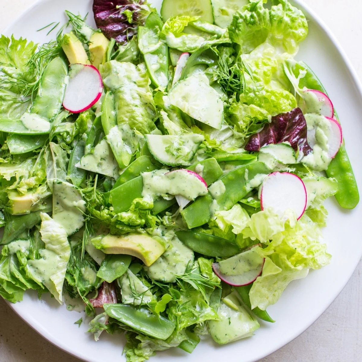 Chopped herbs and creamy avocado brighten this crisp Green Goddess salad, perfect for a refreshing lunch side.