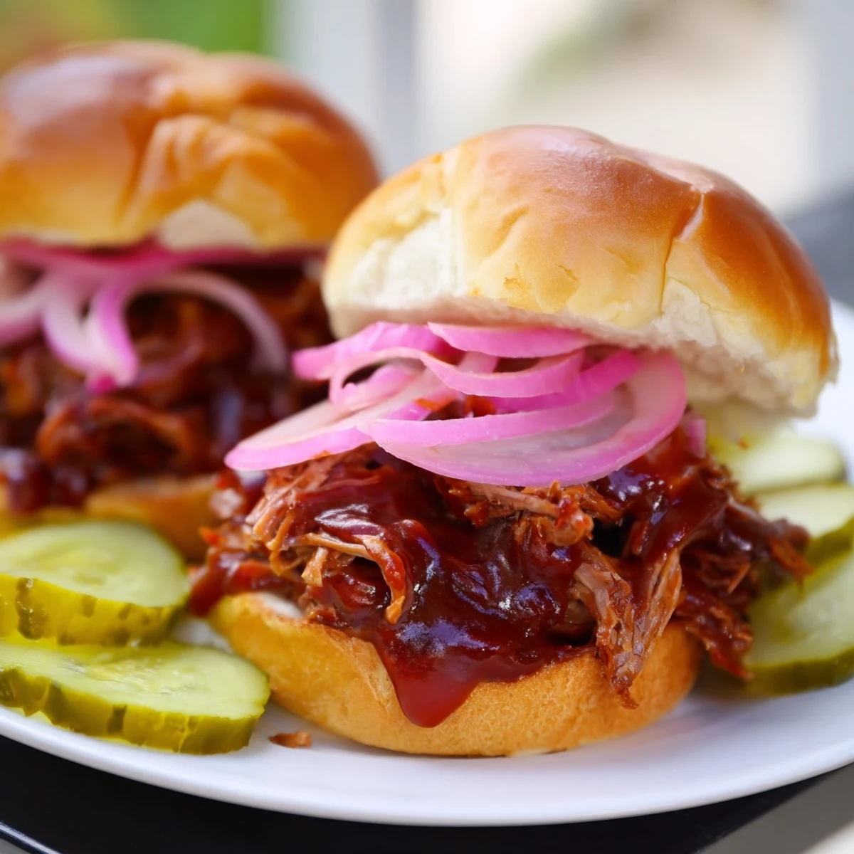 Golden toasted buns cradle smoky pulled beef, topped with crunchy onions and pickles, creating a mouthwatering party appetizer or casual dinner.