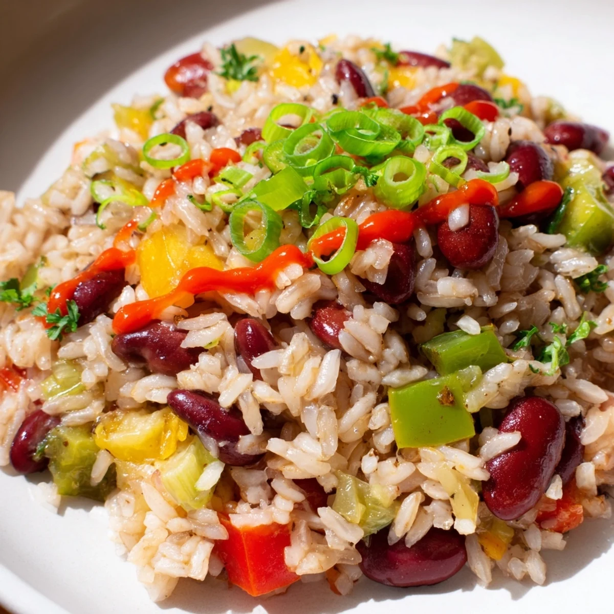 Steam rises from a pot of Mardi Gras Rice and Beans, showing colorful peppers, red beans, and fluffy rice.
