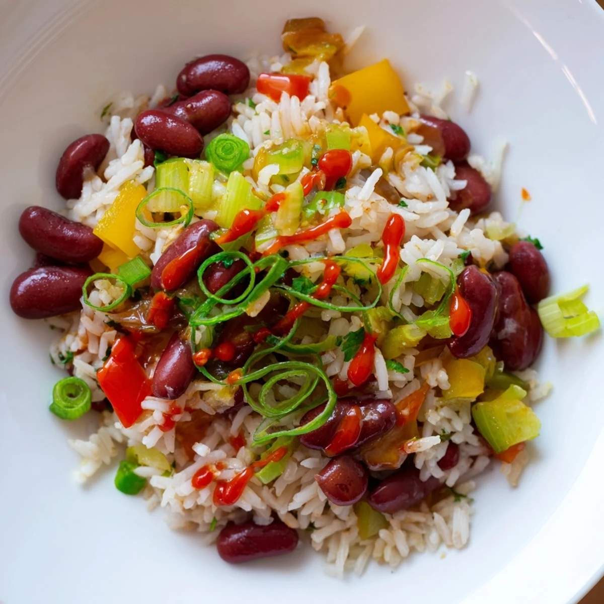 Serving of Mardi Gras Rice and Beans with a dash of hot sauce and a side of golden cornbread.