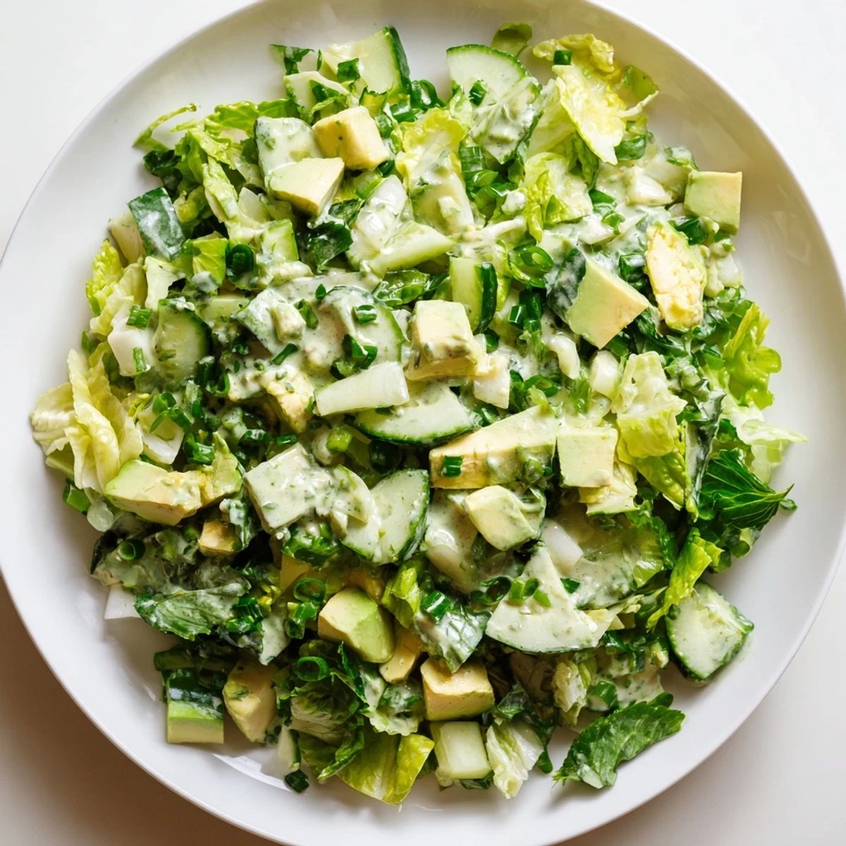 Bowl of Green Goddess Salad with avocado, spinach, and cabbage, served as a light, refreshing vegetarian lunch.