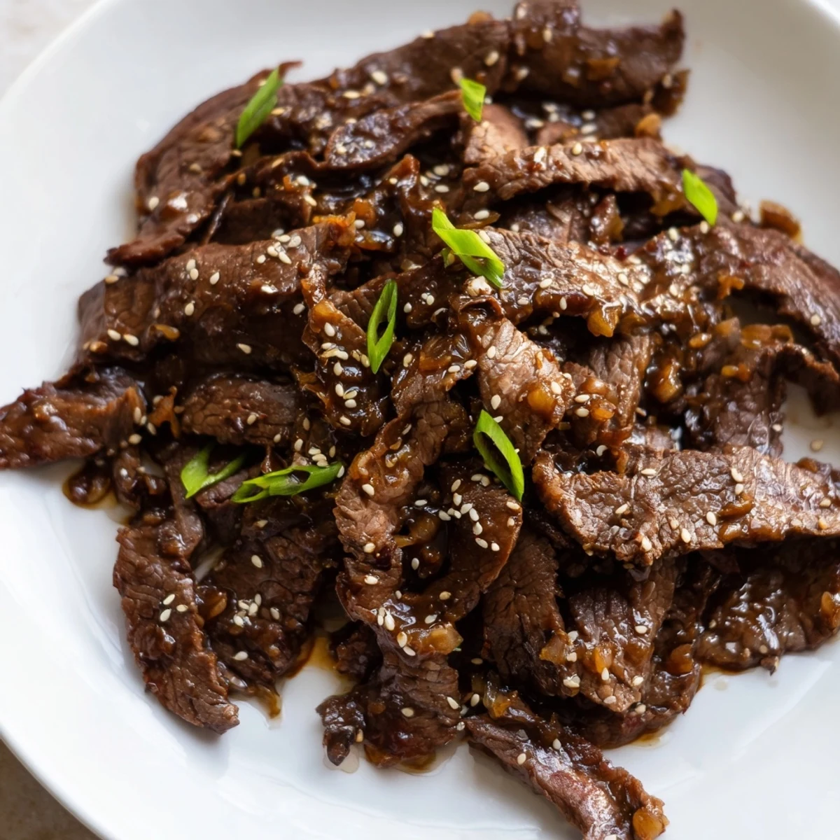 Garnished with green onions and sesame seeds, Ultimate Slow Cooker Mongolian Beef pairs perfectly with fluffy steamed rice.