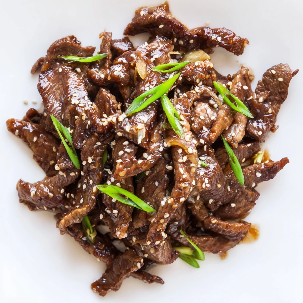 A close-up of Ultimate Slow Cooker Mongolian Beef served over fluffy white rice at dinner.