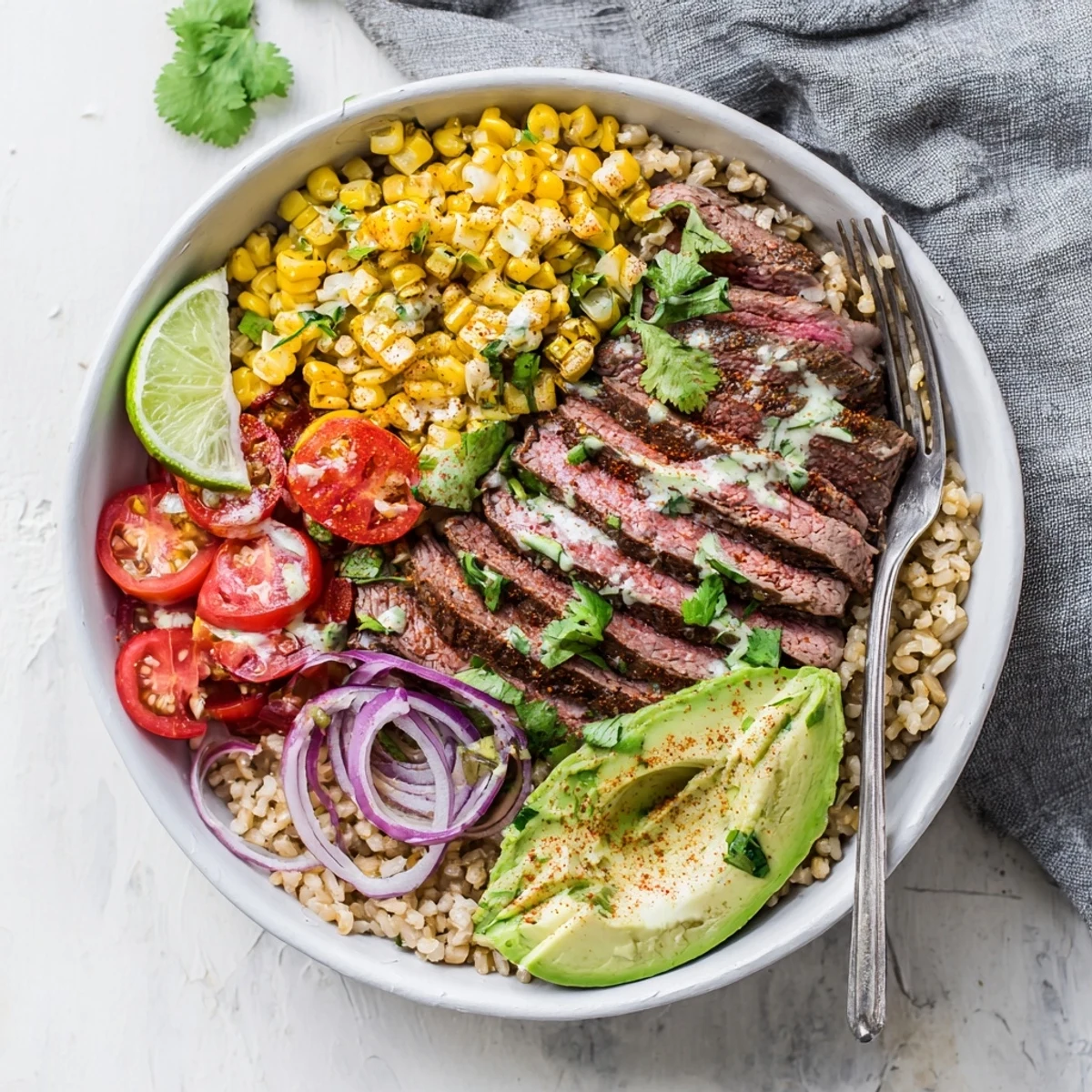 A zesty lime dressing enhances the rich avocado and smoky corn in this fresh Steak Avocado Roasted Corn Bowl.
