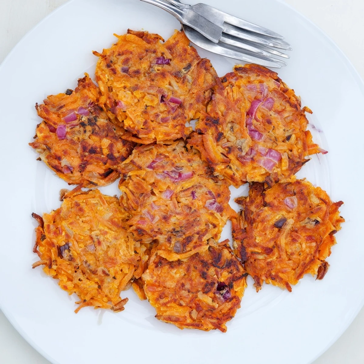 A close-up shows seasoned Healthy Sweet Potato Hash Browns with a tender orange interior, topped with fresh sliced green onions for extra color.