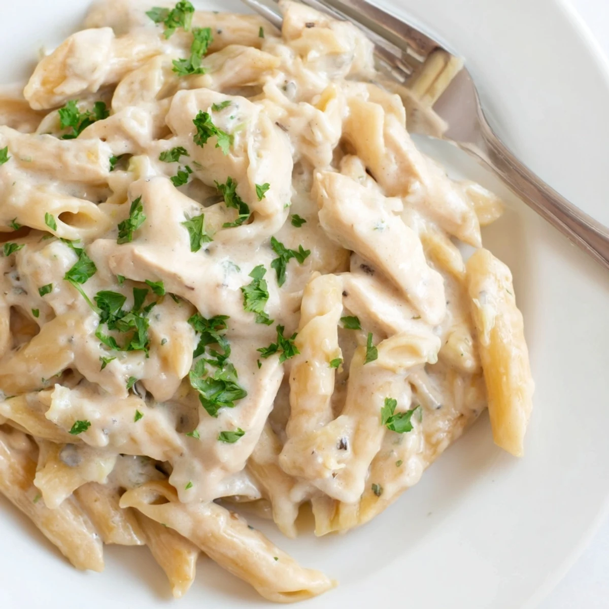 Serve this Crockpot Garlic Parmesan Chicken Pasta in a rustic bowl, paired with a side salad and garlic bread for dinner.