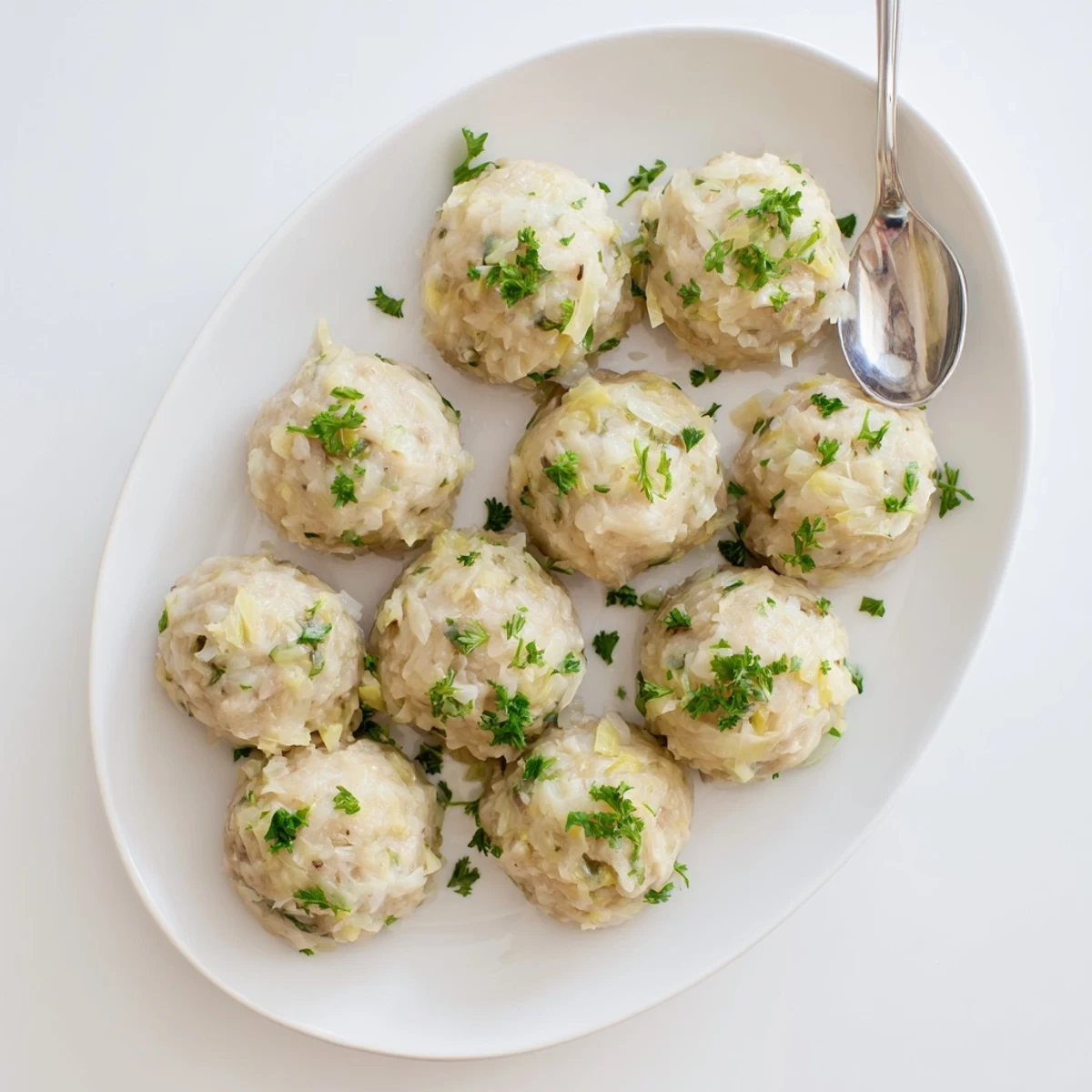 Golden German Cabbage Dumplings simmer in savory broth, ready to serve with melted butter and creamy mushroom sauce on the side.