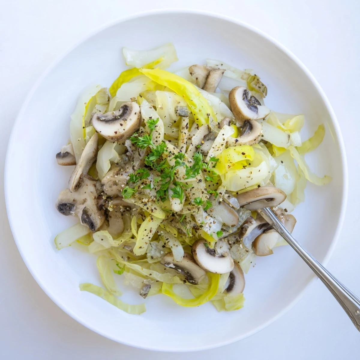 A close-up of the Vegetarian Cabbage Mushroom Sauté, featuring golden-brown mushrooms and tender green cabbage speckled with fresh parsley.