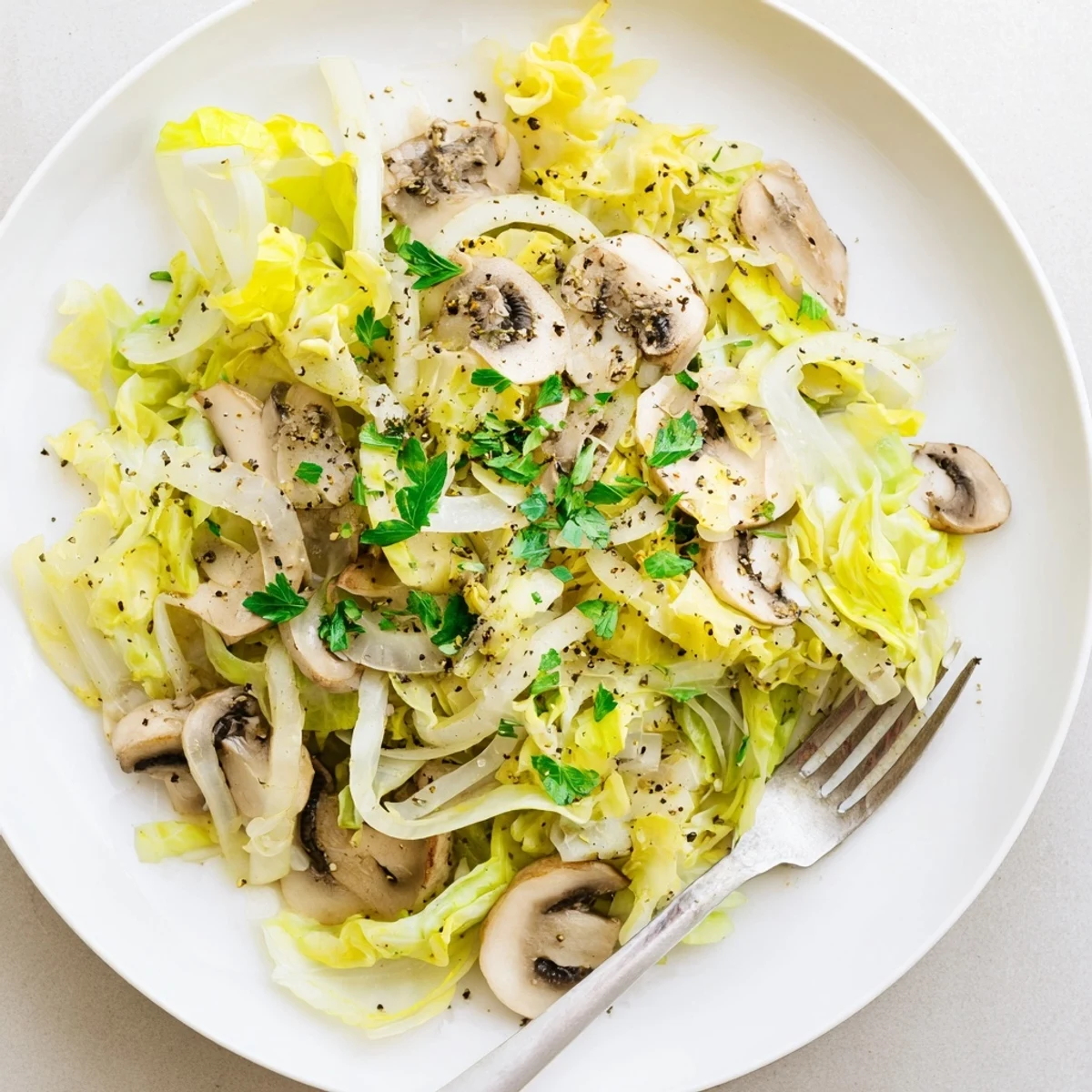 A vibrant skillet of Vegetarian Cabbage Mushroom Sauté, showing sautéed onions and thyme-infused cabbage with a bright, savory finish.