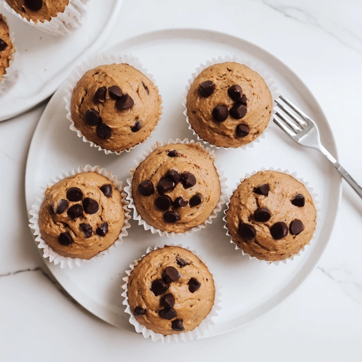 A close-up shot highlights the moist, chewy texture of these French Roast Coffee Muffins with Mochi Flour on a marble countertop.
