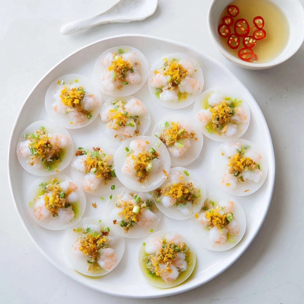 Banh Beo appetizer featuring delicate steamed rice cakes with shrimp topping and fried shallots