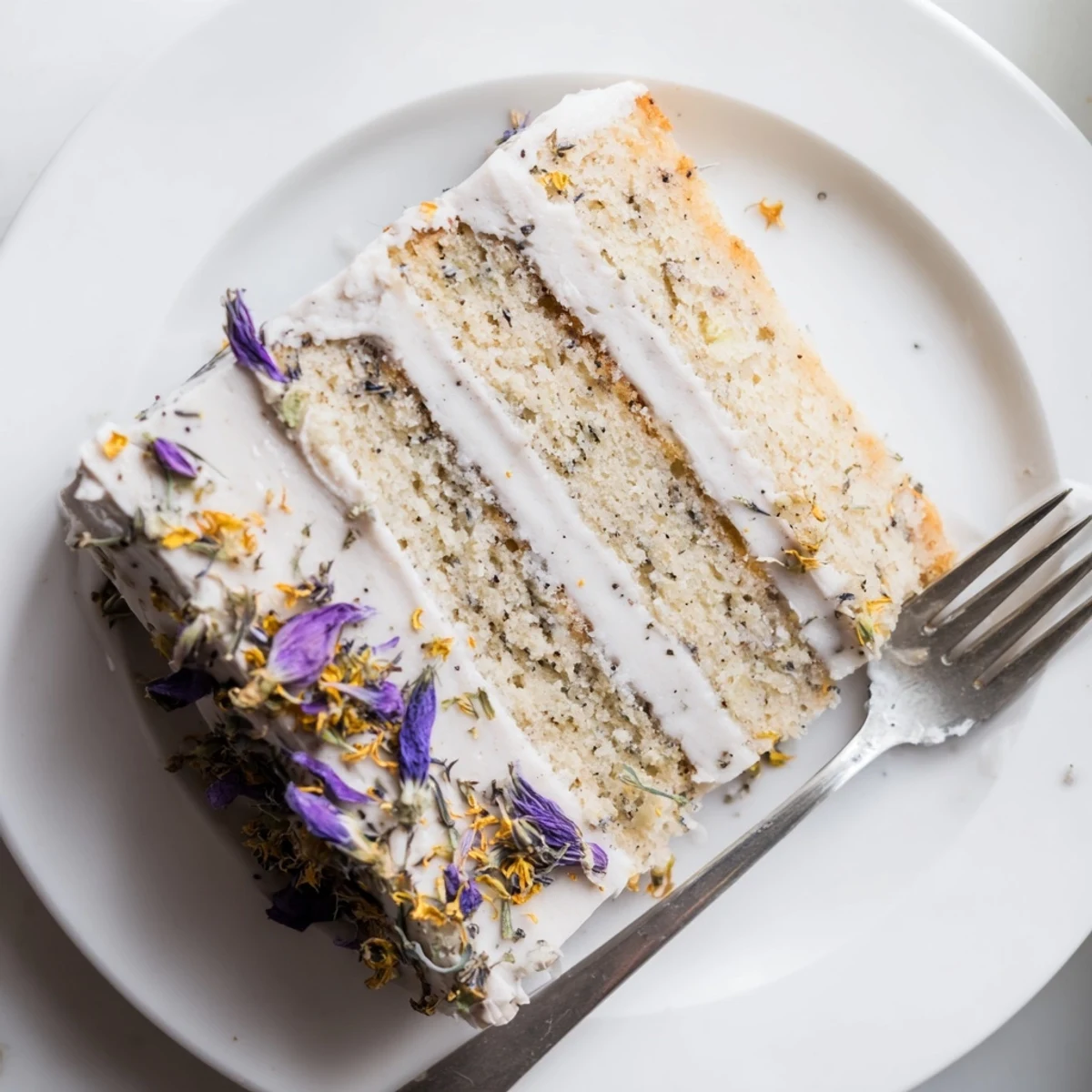 Slice of London Fog cake revealing moist Earl Grey sponge and creamy vanilla frosting layers