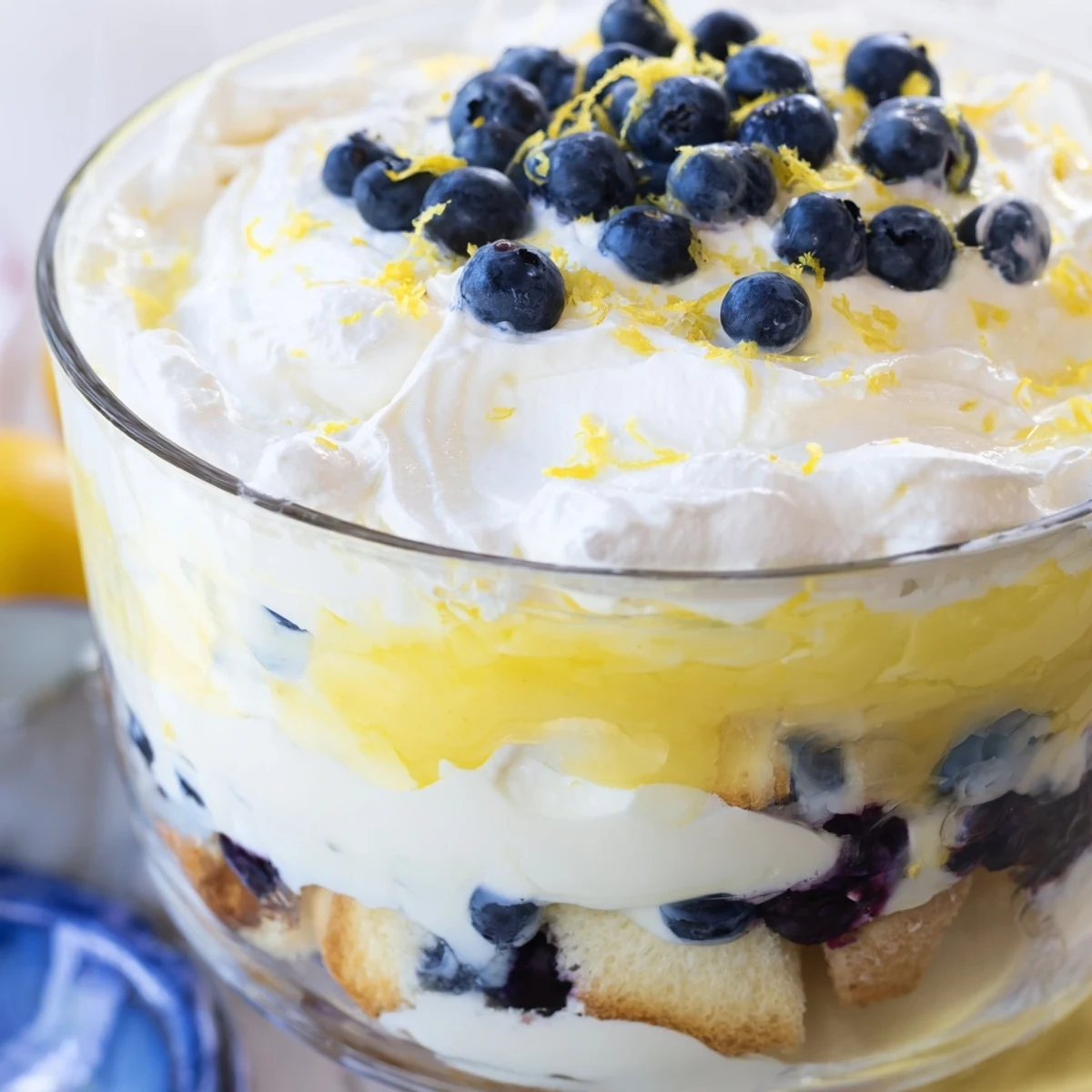 Close-up of easy lemon blueberry trifle featuring cube cake layers with sweet blueberries and lemon curd