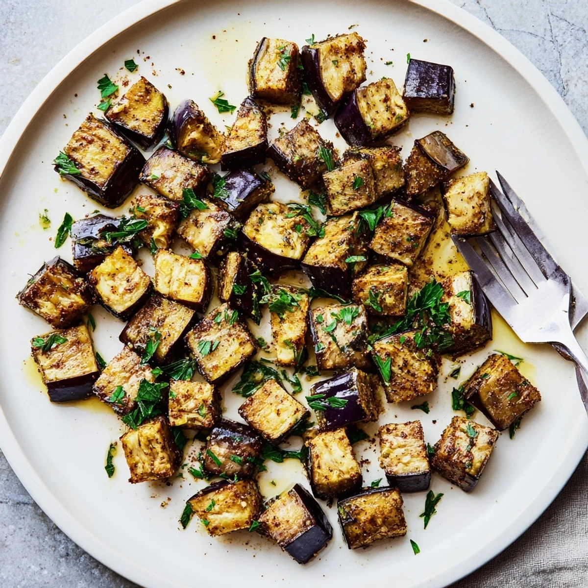 Golden brown low calorie air fryer eggplant cubes crispy on edges with parsley garnish