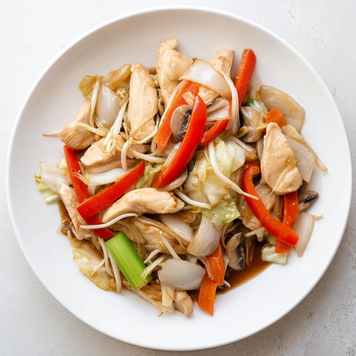 Hearty Chop Suey plated with steamed rice showcasing vibrant bell peppers, bean sprouts, and aromatic sesame sauce finish