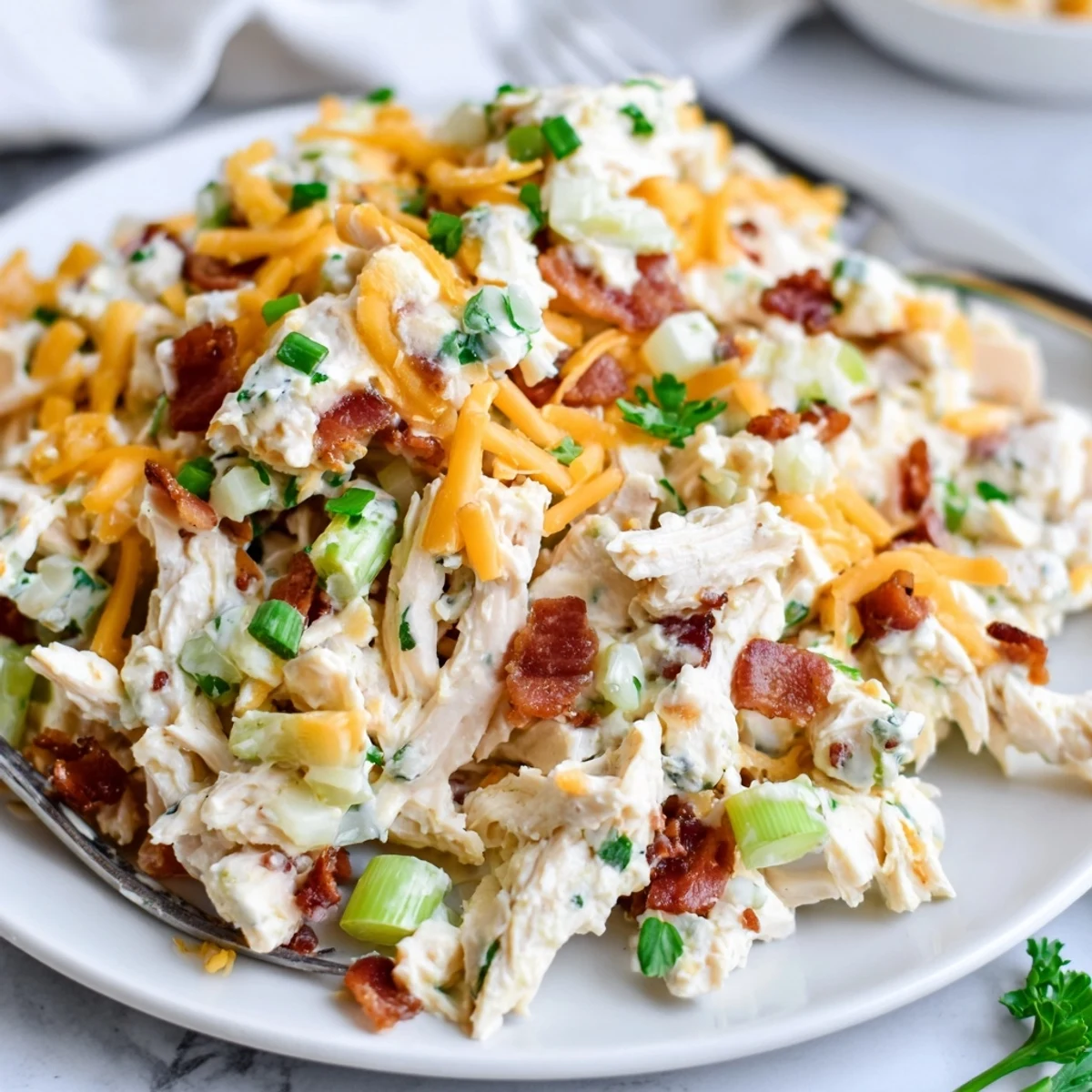 Close-up of protein-packed jalapeno popper chicken salad showing creamy cottage cheese dressing coating shredded chicken with smoky bacon bits and garnish