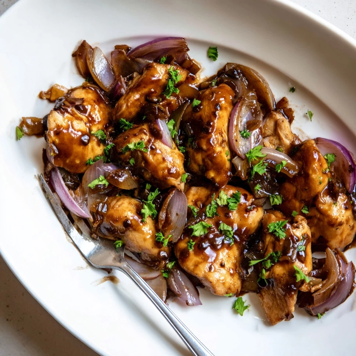 Golden slow cooker balsamic chicken thighs glazed in rich dark sauce garnished with fresh parsley