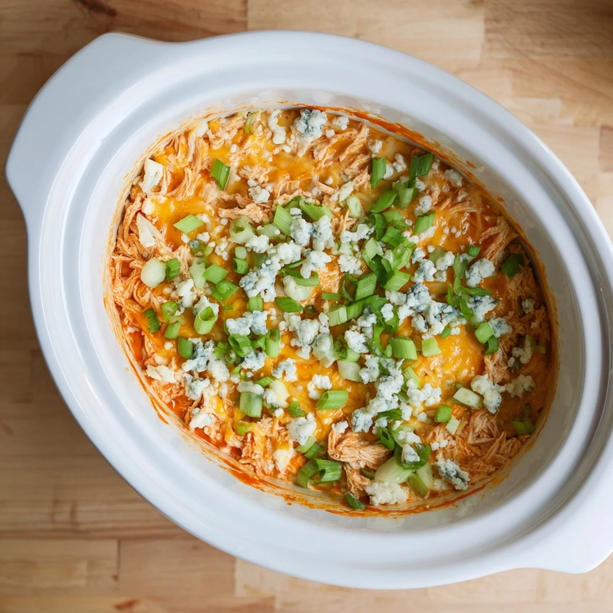 Spicy slow cooker Buffalo Chicken Dip served warm with crispy tortilla chips and fresh vegetable crudités