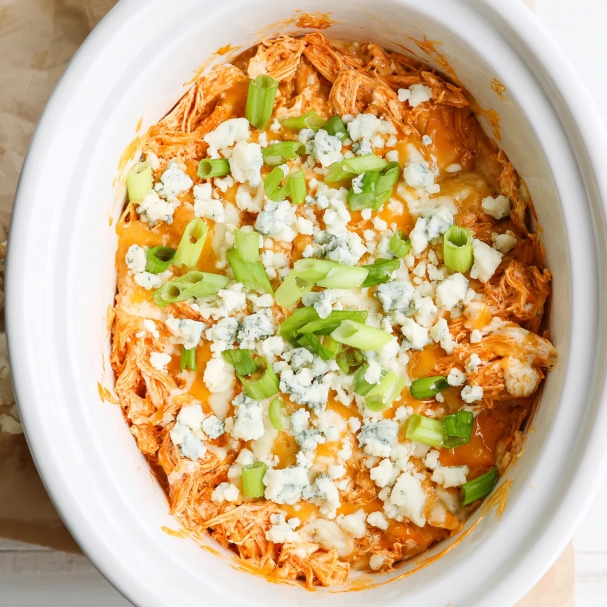 Golden Buffalo Chicken Dip in a crockpot featuring shredded chicken breast coated in tangy red buffalo sauce