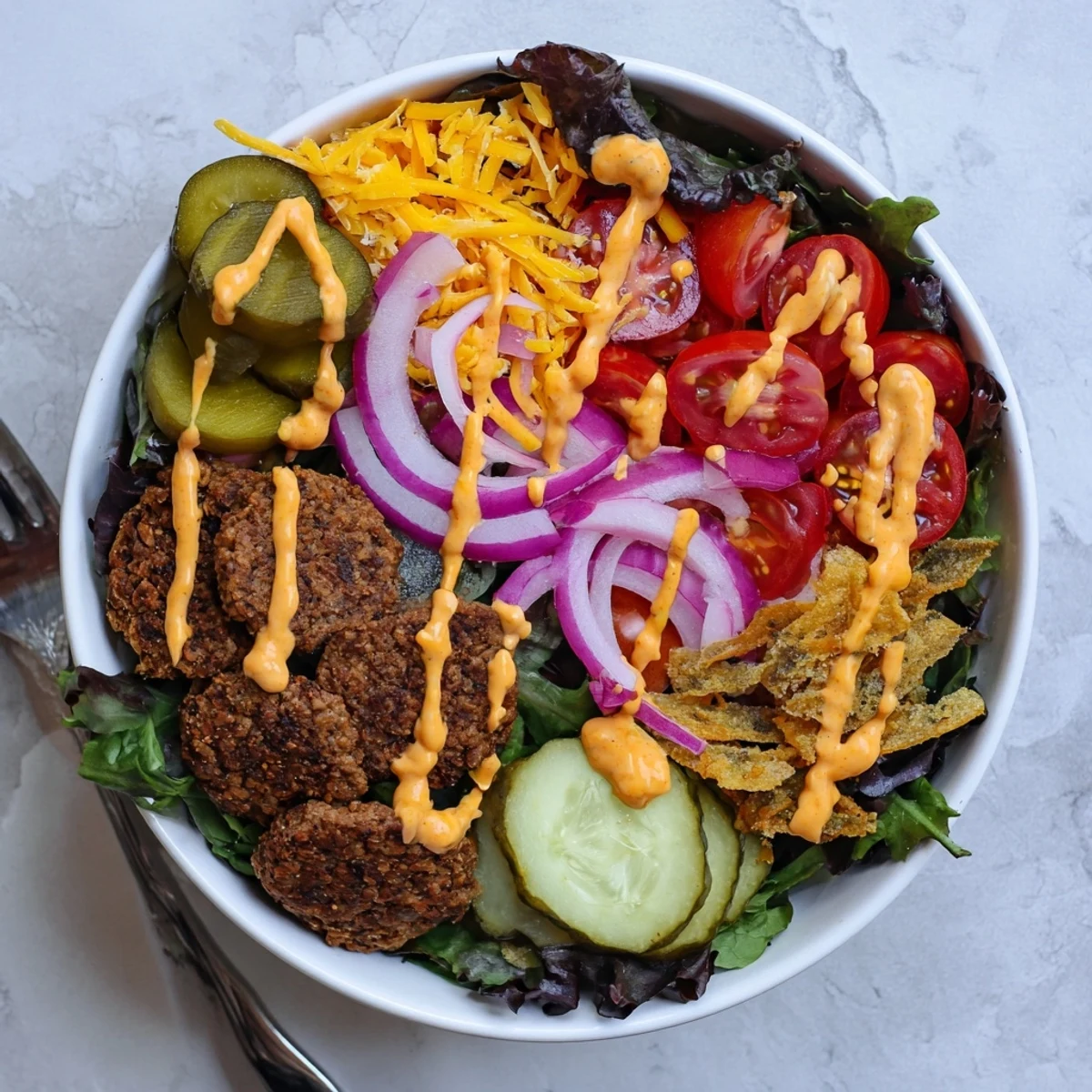 Low-carb smash burger bowl loaded with juicy smashed beef, tangy pickles, cherry tomatoes, and creamy special sauce drizzle