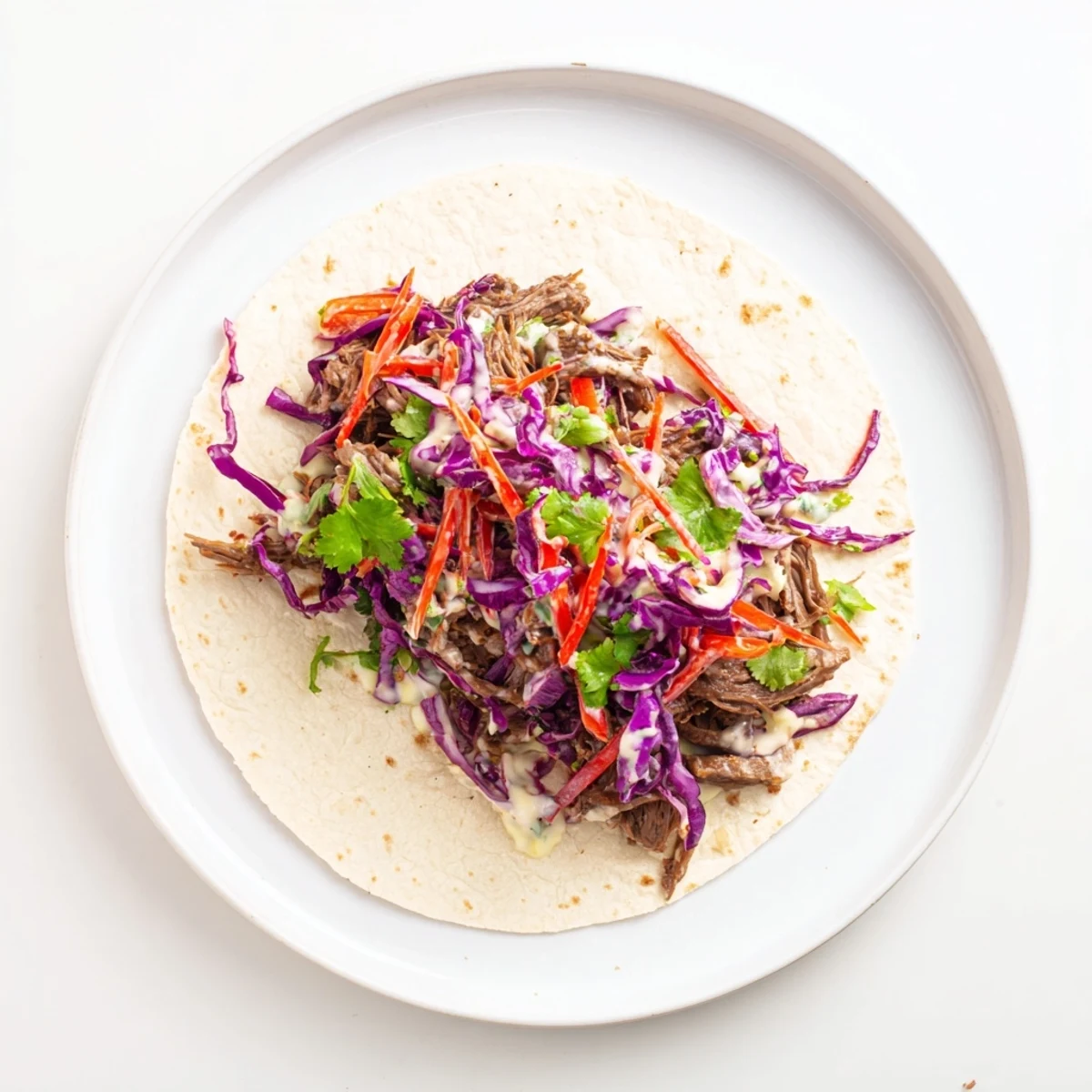 Easy sweet and smoky BBQ beef wraps filled with vibrant red and green cabbage slaw