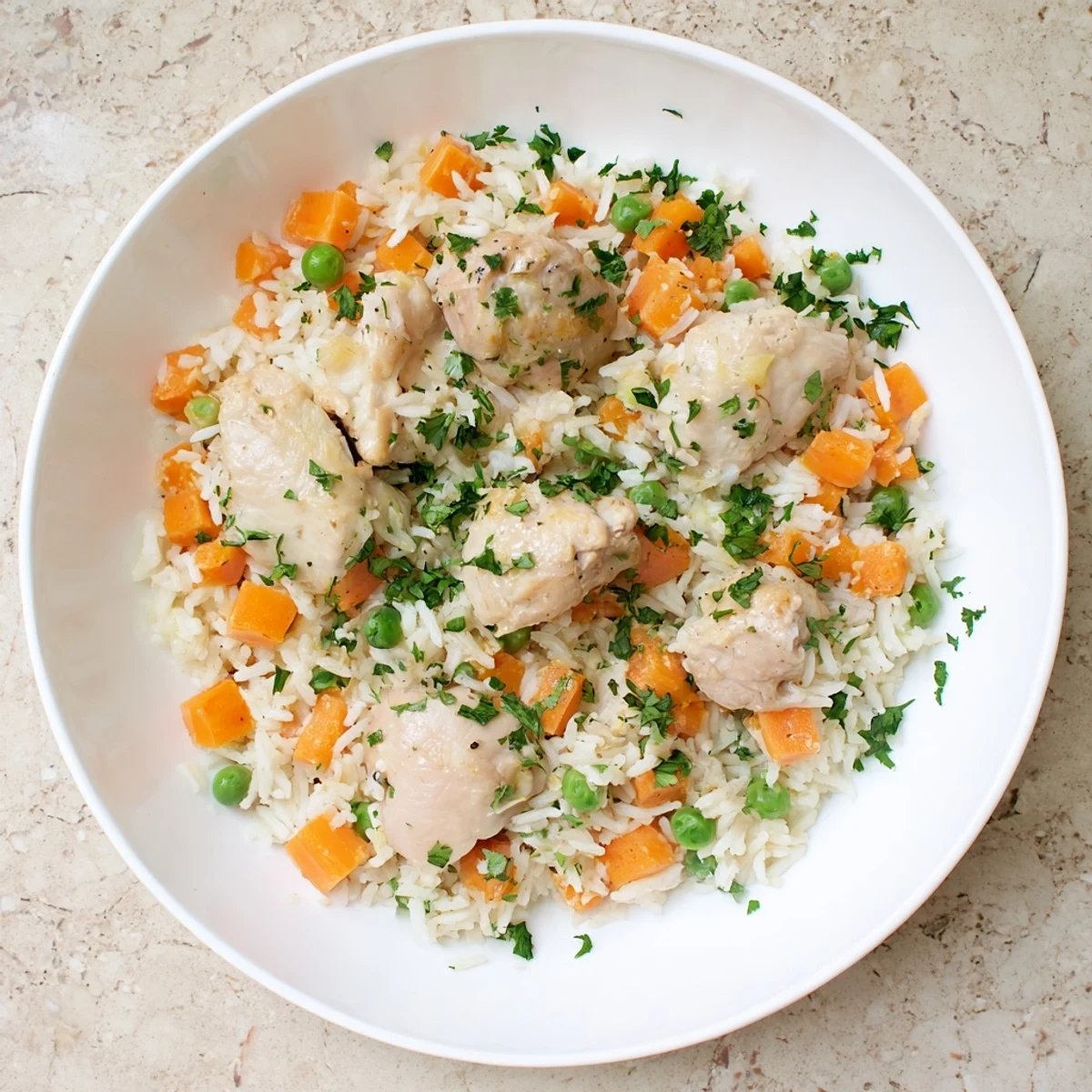 Steaming bowl of comforting chicken and rice with vibrant vegetables, ready for a family-friendly weeknight meal