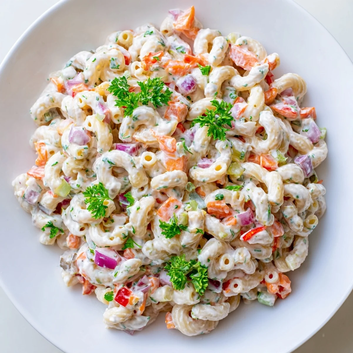 Close-up of classic macaroni salad featuring tender pasta and crunchy red bell pepper pieces