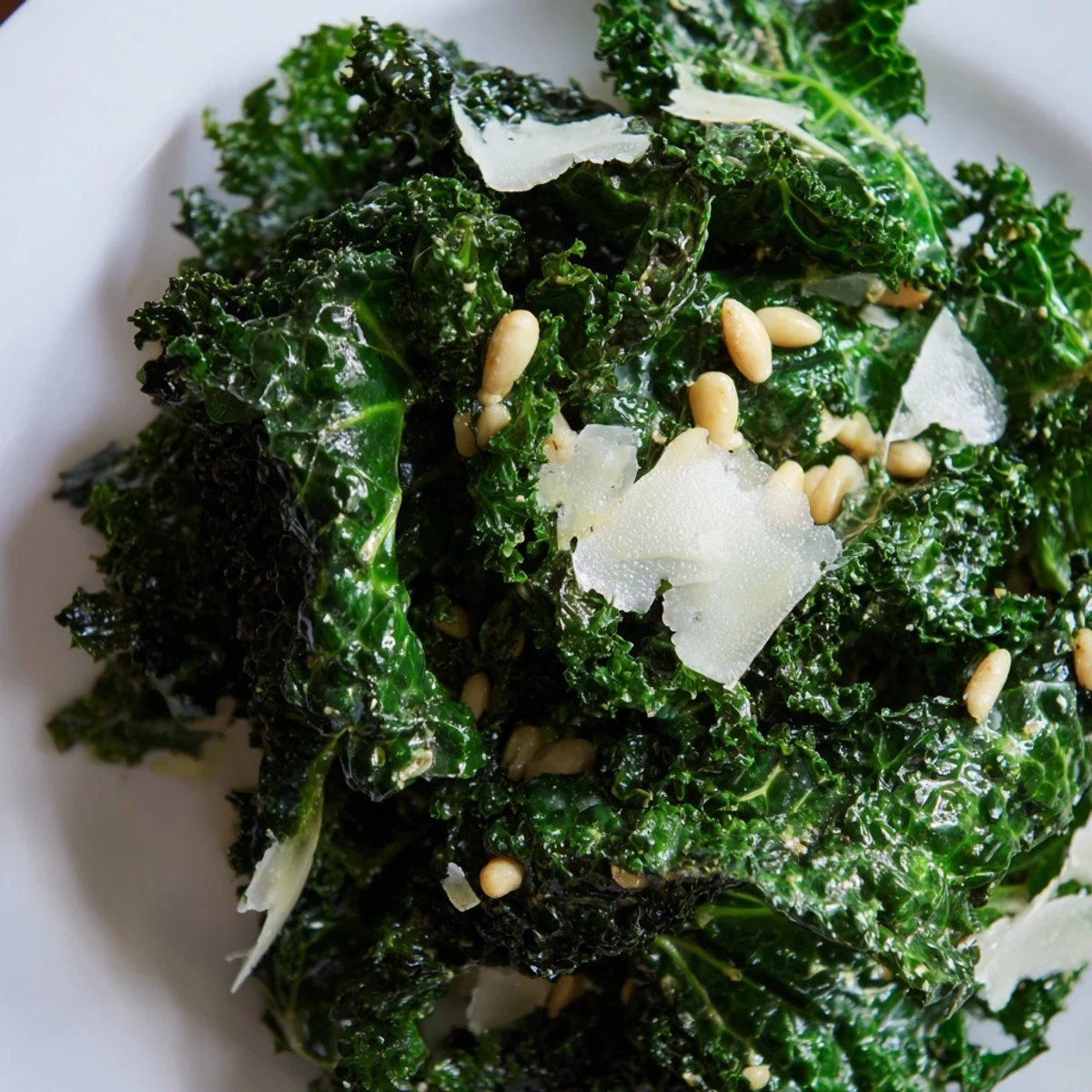 Massaged kale leaves glistening with zesty garlic-lemon dressing in a rustic serving bowl