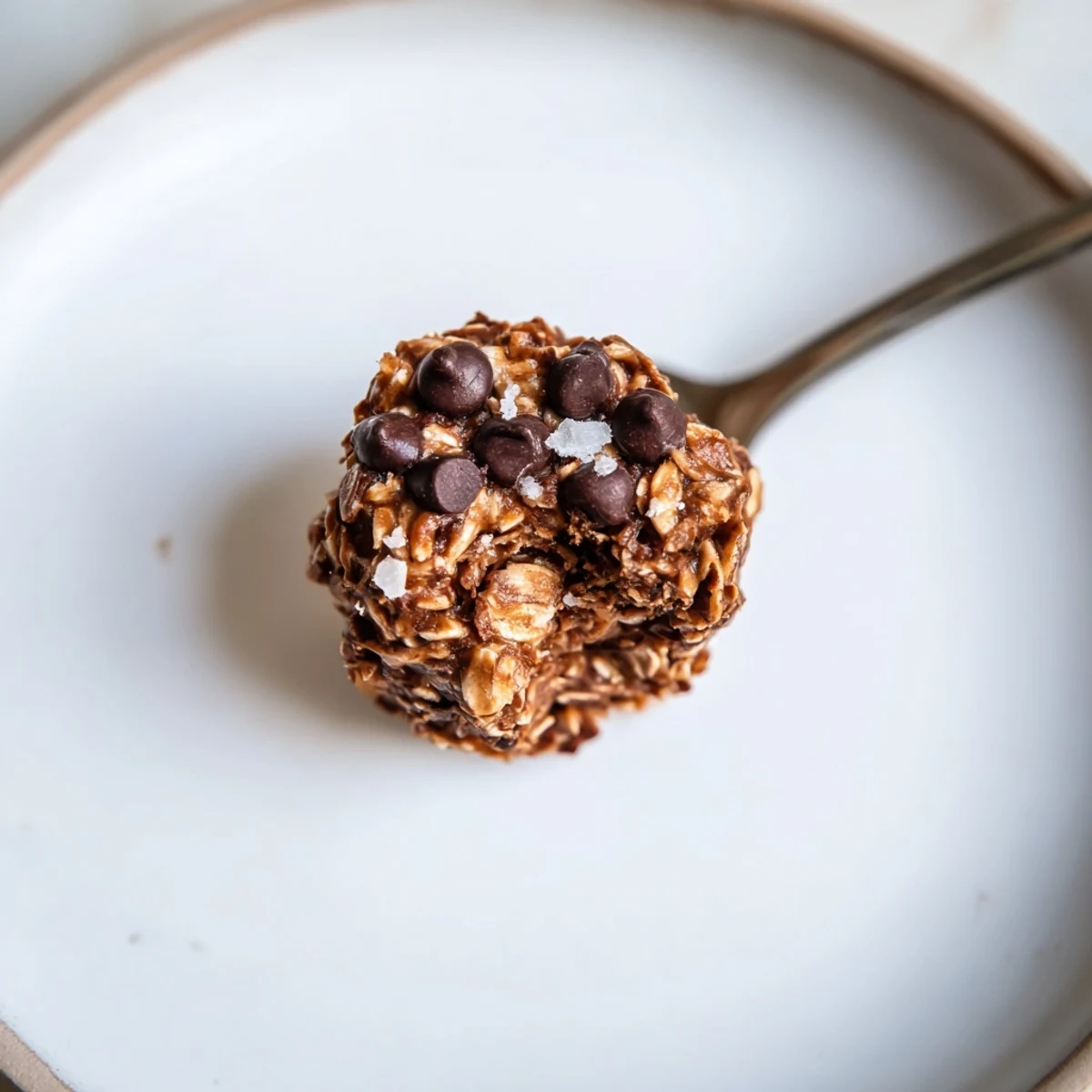 Brownie Protein Bites arranged on parchment, glossy chocolate chips and chewy centers.