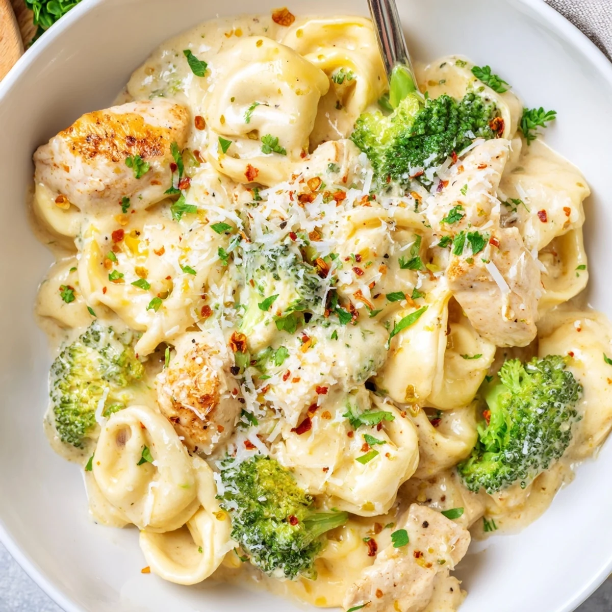 Creamy Garlic Parmesan Tortellini Chicken Broccoli Recipe simmered in silky sauce, topped with Parmesan