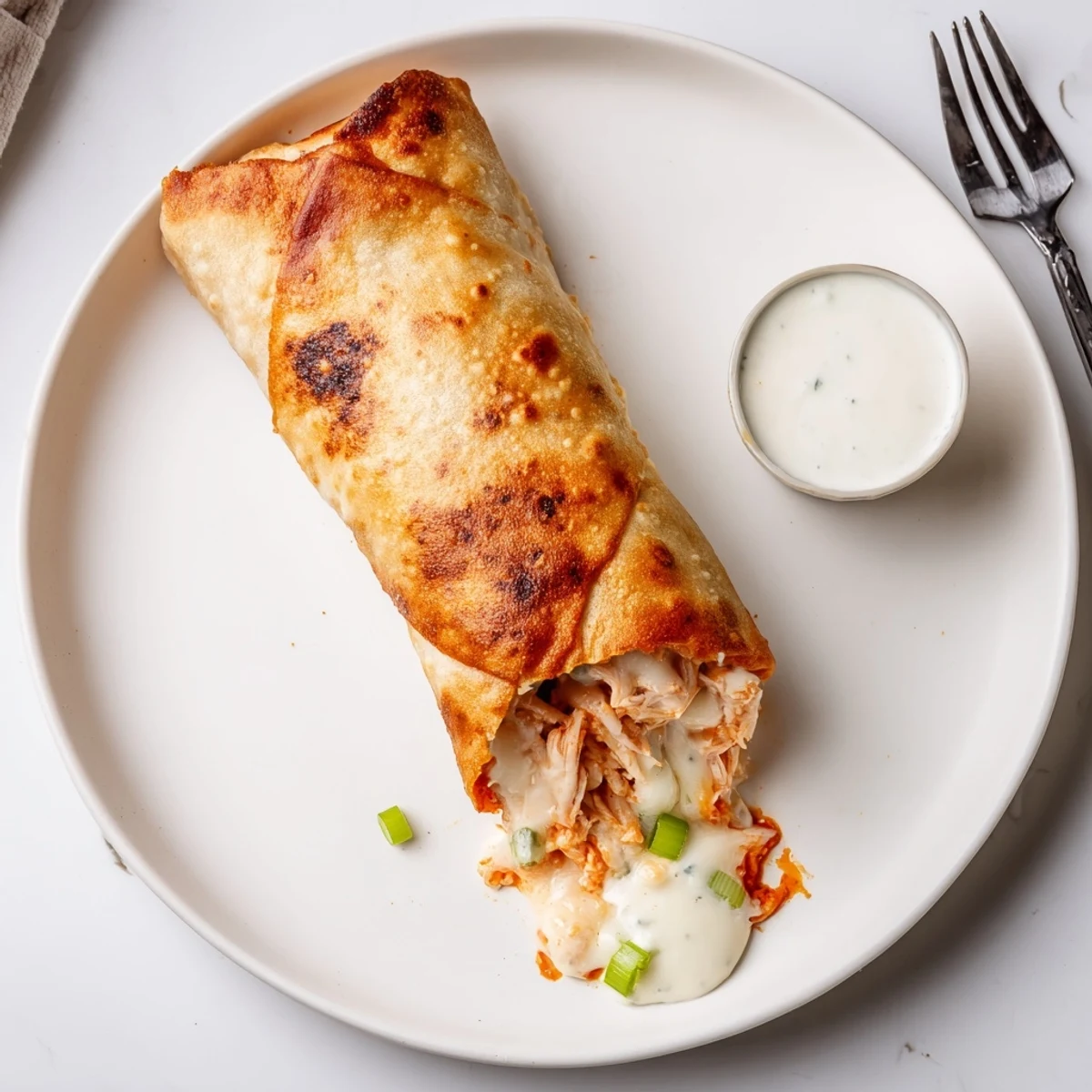 Warm Buffalo Chicken Egg Rolls resting on plate, paired with cold lager.