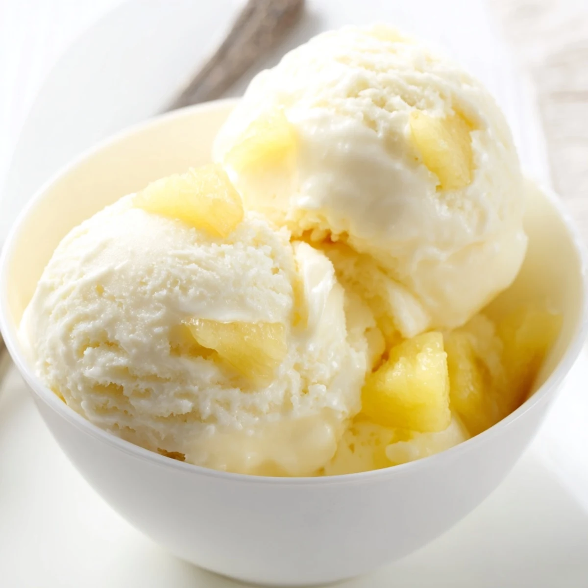 Creamy Pineapple Ice Cream scoops in a bowl, bright tropical aroma.  