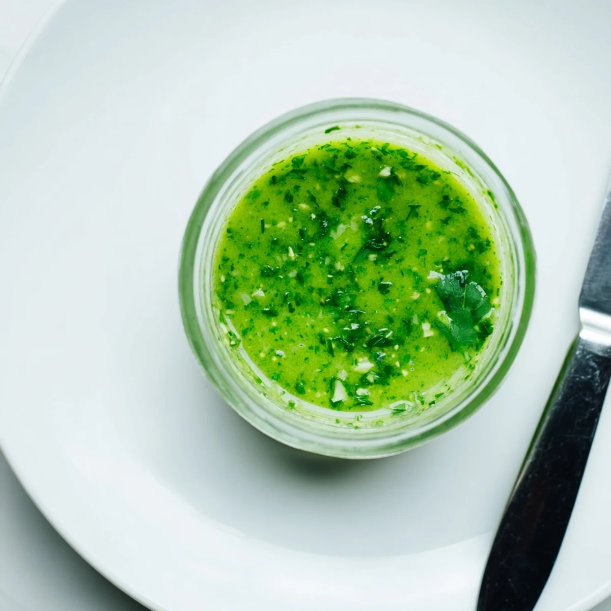 Vibrant green cilantro lime fresh dressing drizzled over crisp garden salad in white bowl