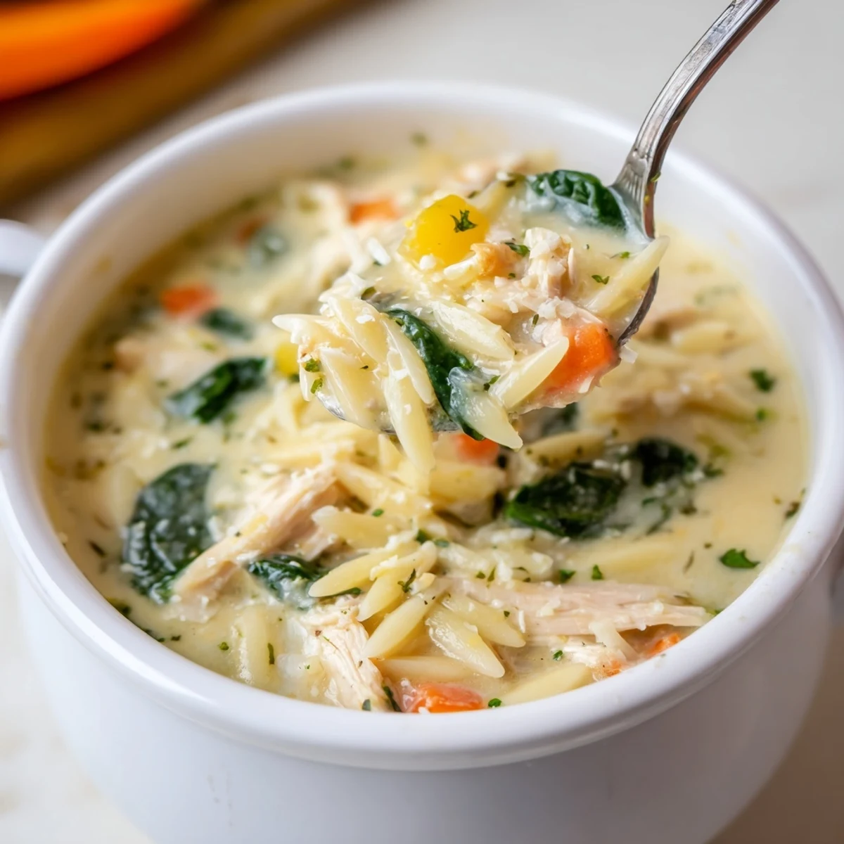 Creamy Chicken Florentine Soup With Orzo ladled next to crusty bread, Parmesan sprinkled