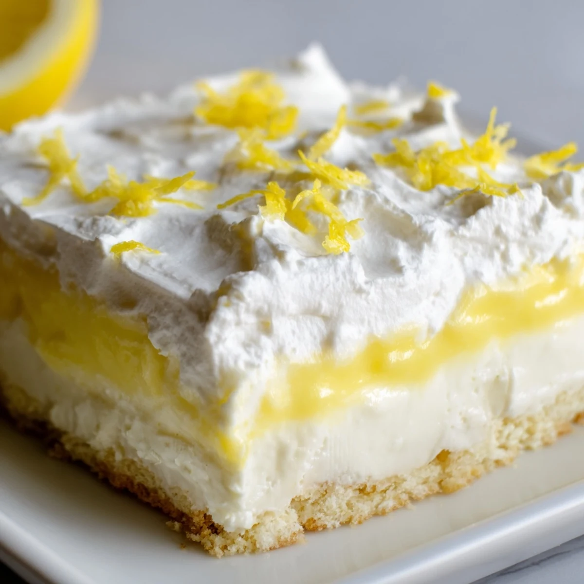 Golden lemon lush cake slice revealing fluffy cream cheese layers and tangy lemon pudding filling