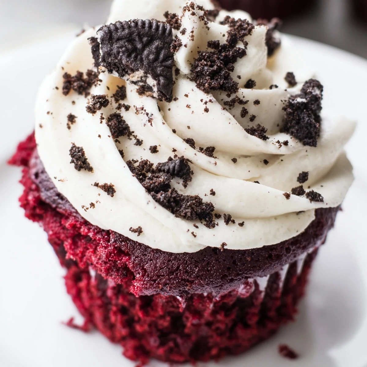 Rich red velvet Oreo cupcakes with swirls of tangy cream cheese frosting and cookie crumbs