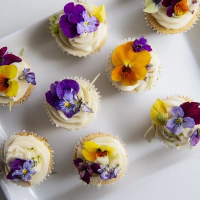 Tender Wild Flower Cupcakes decorated with fresh edible flowers and light frosting for afternoon tea.