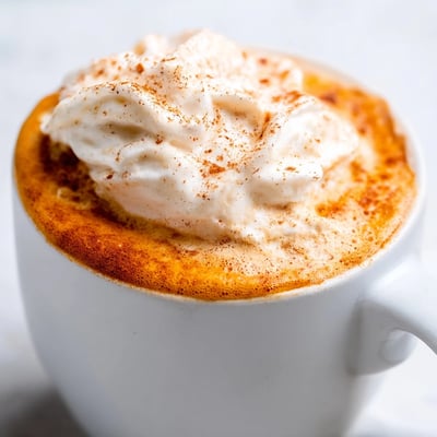 Steaming homemade pumpkin spice latte in a cozy mug on a crisp autumn morning