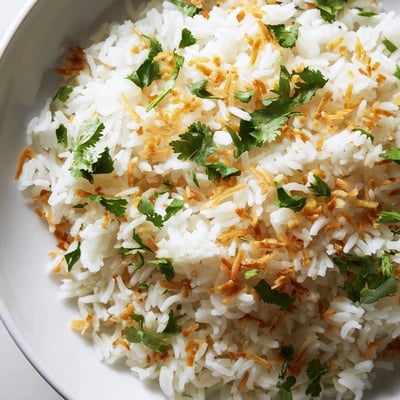 Fluffy coconut rice served alongside a vibrant Thai curry in a white bowl
